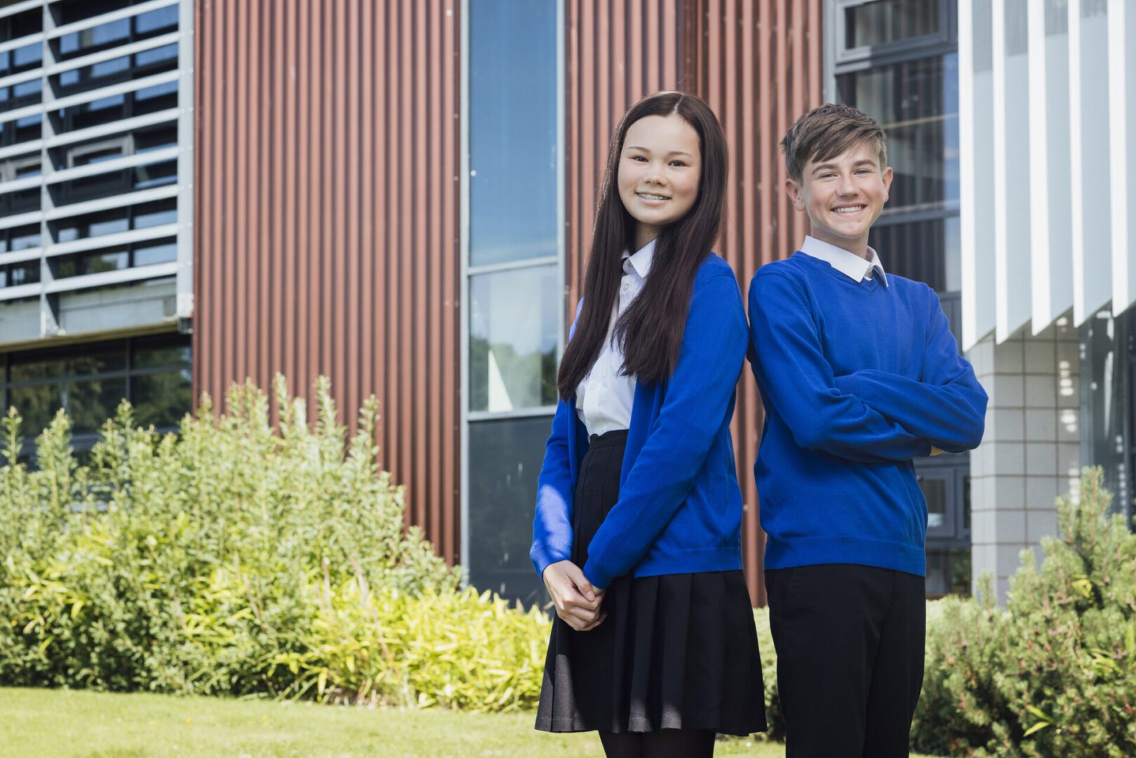 Students in blue uniforms outside modern building.