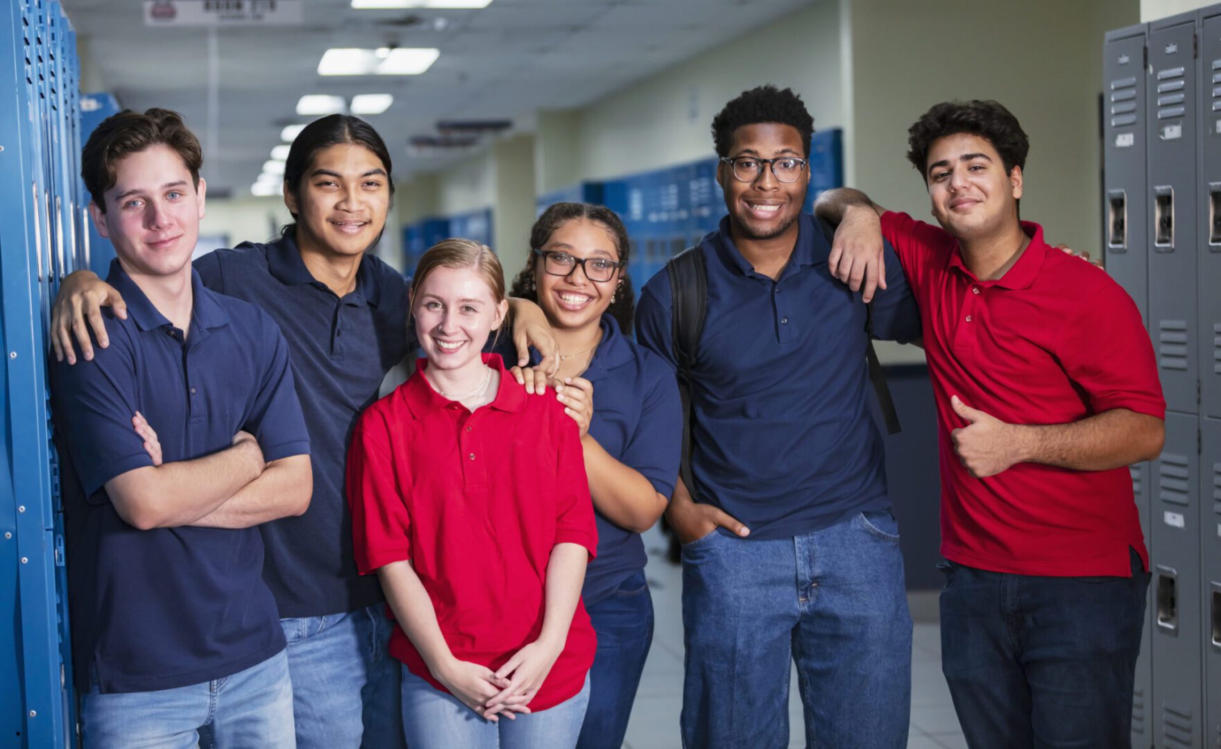 Group of smiling students in school hallway.