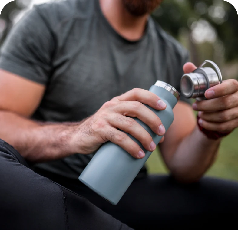Man holding a water bottle outdoors.