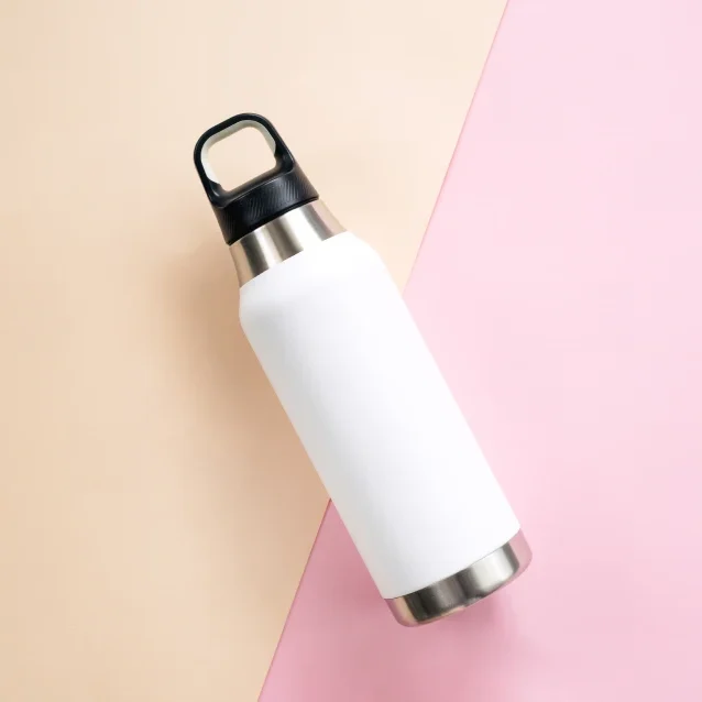 White water bottle on pink and beige background.